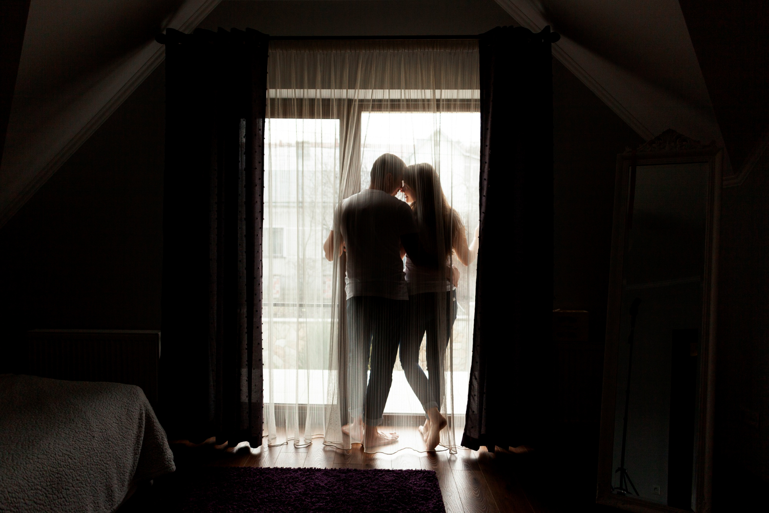 Влюбленная пара стоит у окна